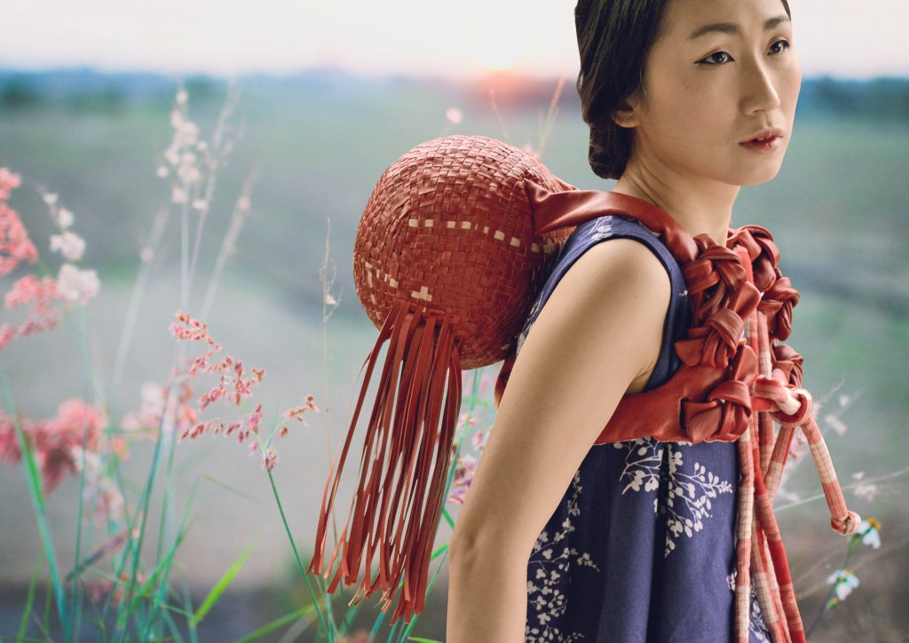 Girl holding weaved leather backpack