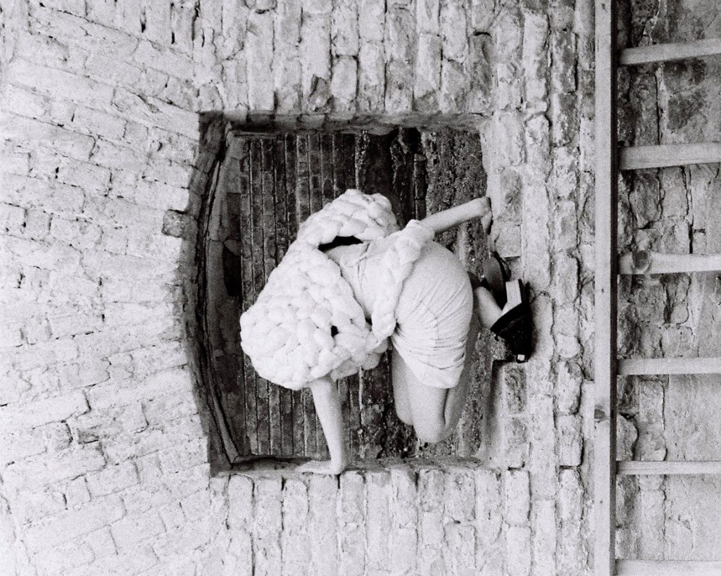 Girl with big jacket standing on a wall