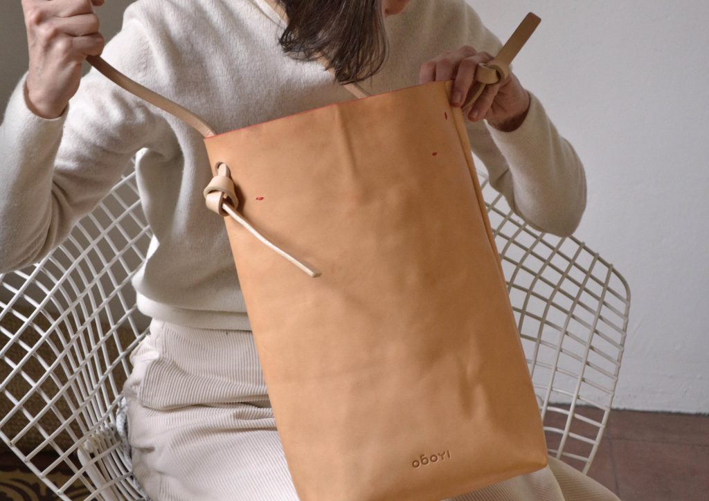 Woman holding beige shopper bag in leather