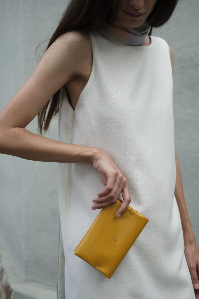 woman holding yellow leather wallet